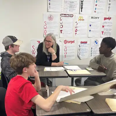 Image of a woman talking to three students